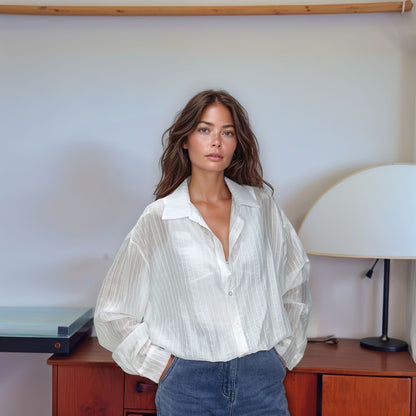 Vista detalhada da textura listrada e acetinada da Blusa Olívia na cor bege, enfatizando a composição de 85% tencel e 15% poliéster.