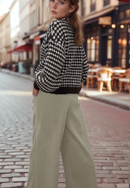 Woman wearing beige velour wide-leg pants and black-and-white sweater, Josephine street style