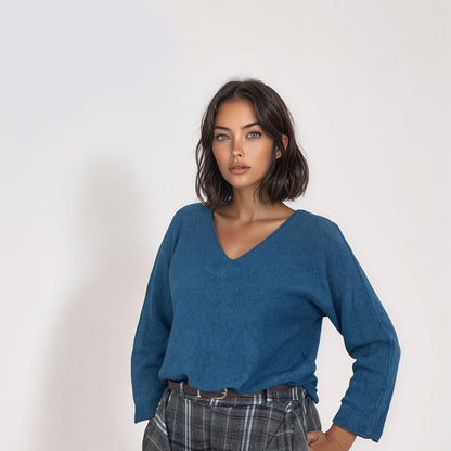 Camisola Kika de malha azul petróleo, com decote em V e mangas compridas, combinada com calças de xadrez cinzento. Moda feminina Josephine.