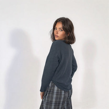 Vista de costas da camisola Kika de malha cinza, com corte descontraído e mangas compridas, combinada com calças de xadrez. Moda feminina Josephine.