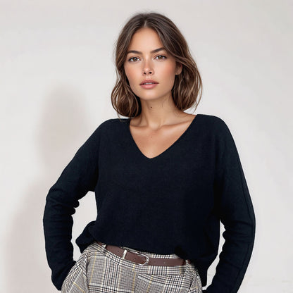 Camisola Kika de malha preta, com decote em V e mangas compridas, combinada com calças de xadrez. Moda feminina Josephine.