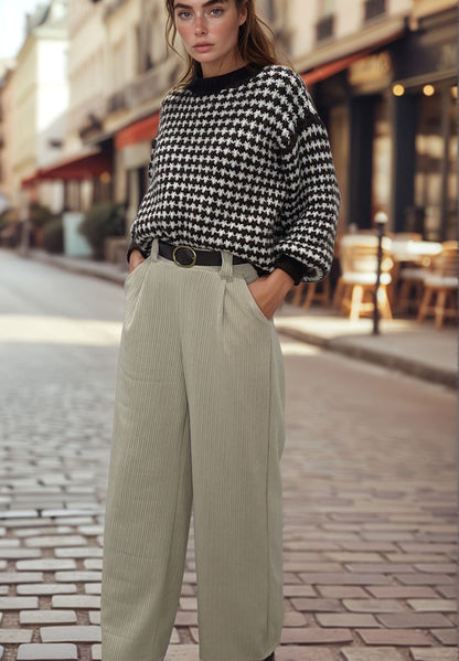 Woman wearing beige velvet trousers with a black buckle belt and a houndstooth sweater, Josephine fashion